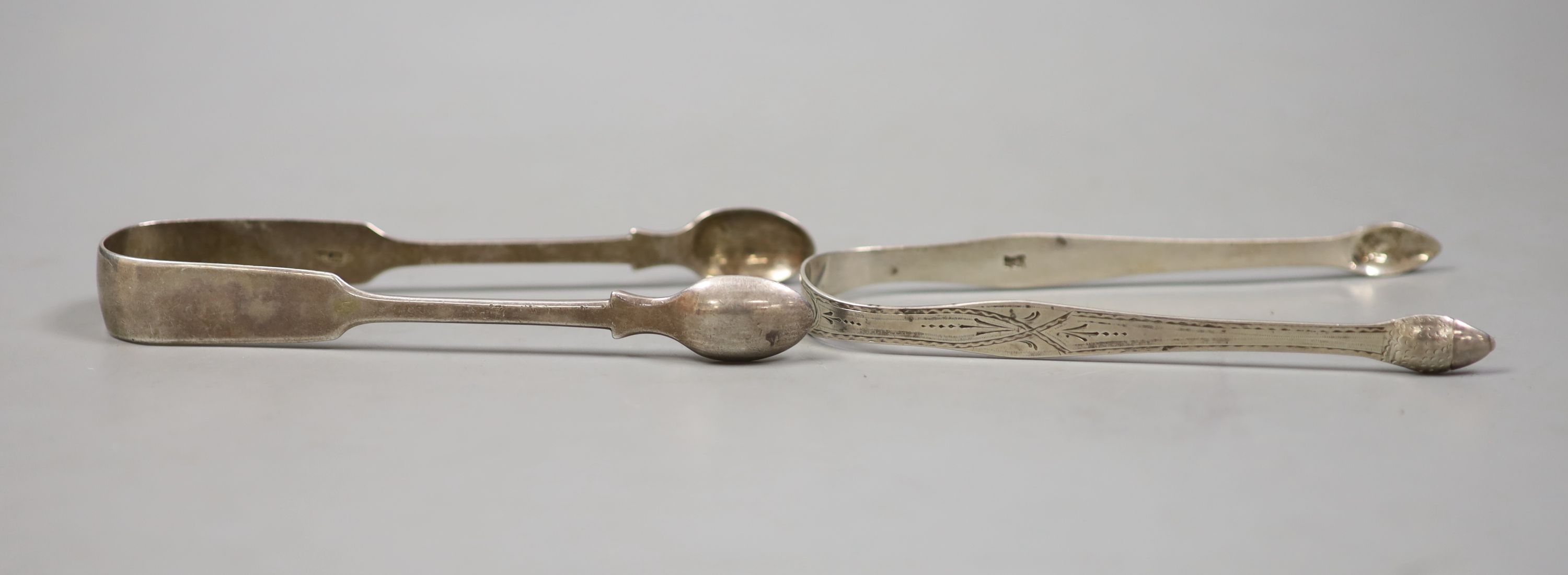 Two pairs of Georgina silver sugar tongs, one with bright cut engraving, largest 15.5cm, 83 grams.